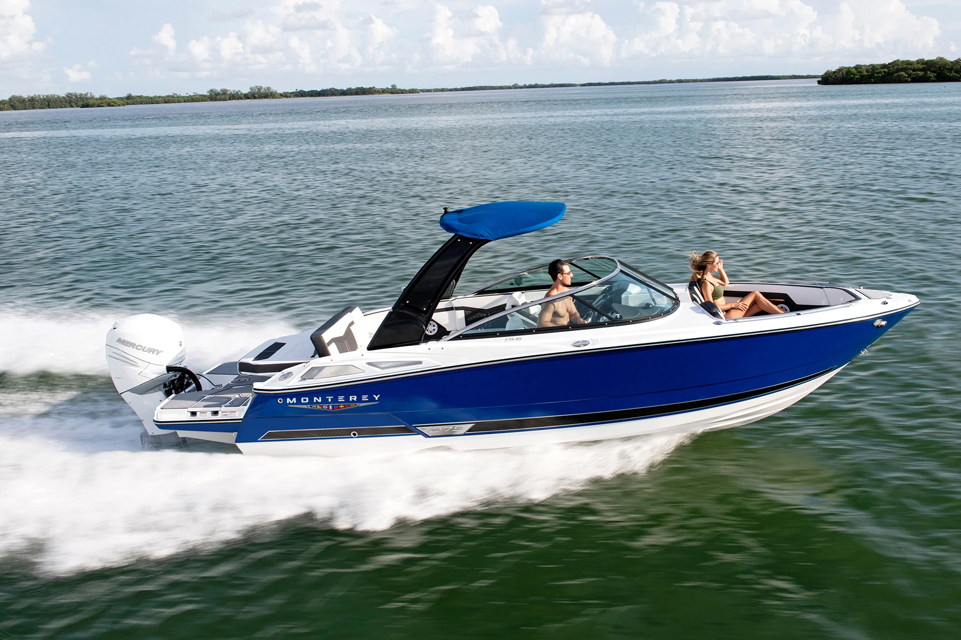 Monterey 275SS cruising at speed with two passengers, showcasing sleek lines and performance