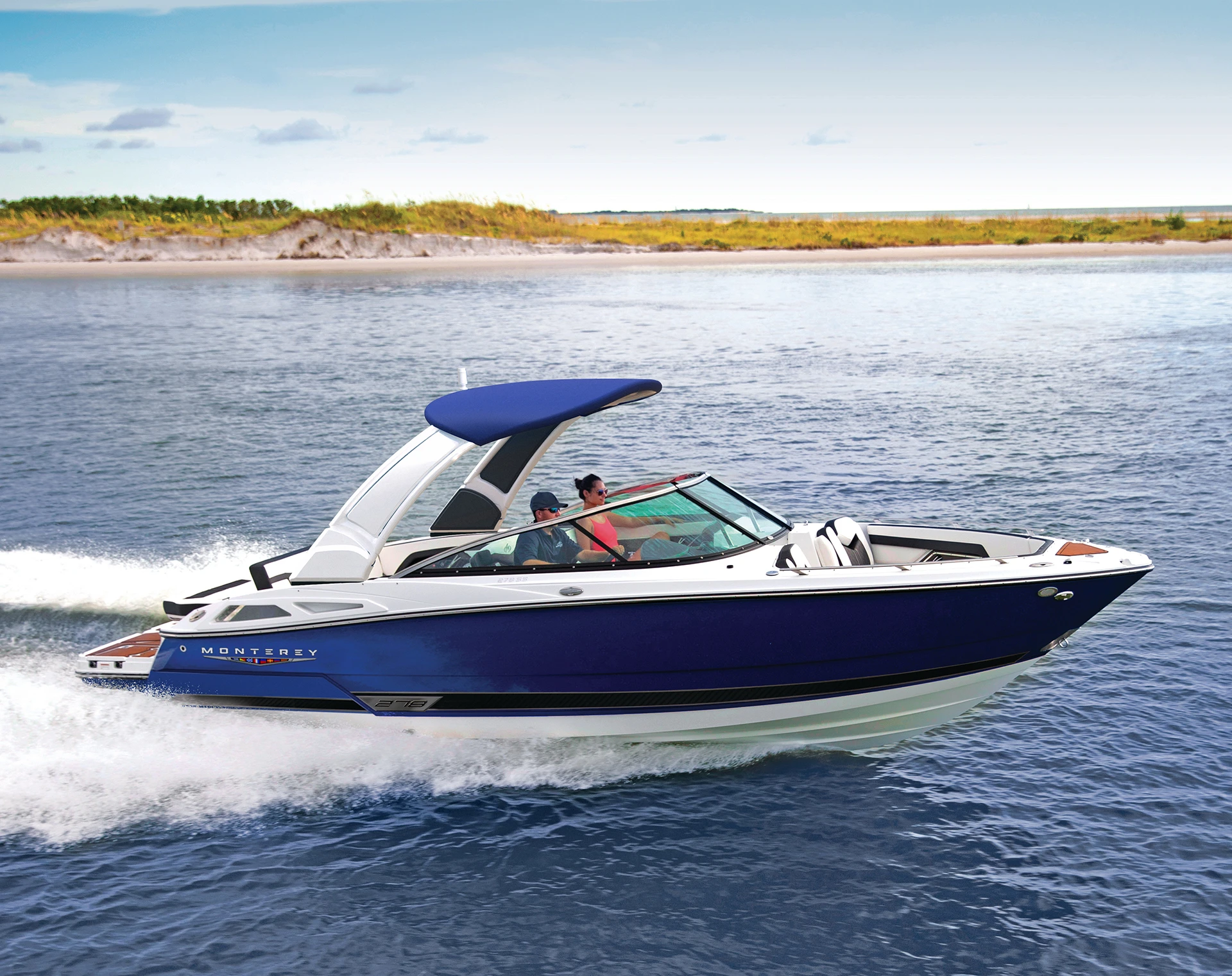 Side view of a blue Monterey 278SS speeding across the water with passengers on board