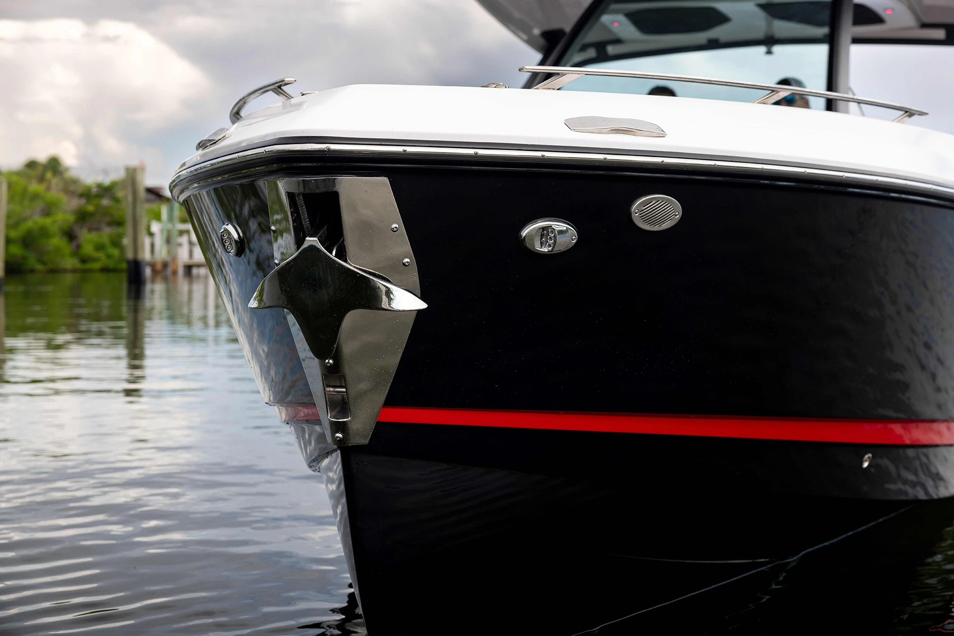 Close-up of bow anchor system on the Monterey Elite 30 OB with polished stainless hardware and a bold black-and-red hull stripe