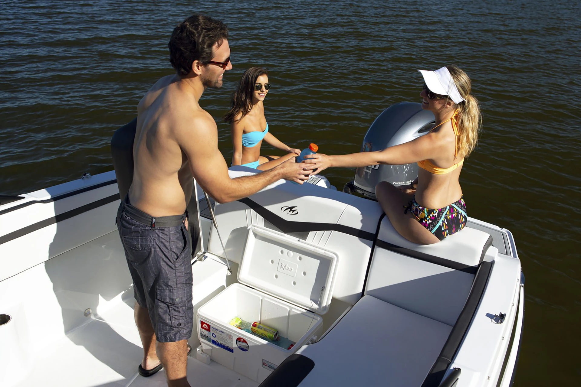 Friends enjoying drinks from the built-in cooler on the Monterey M-225 swim platform