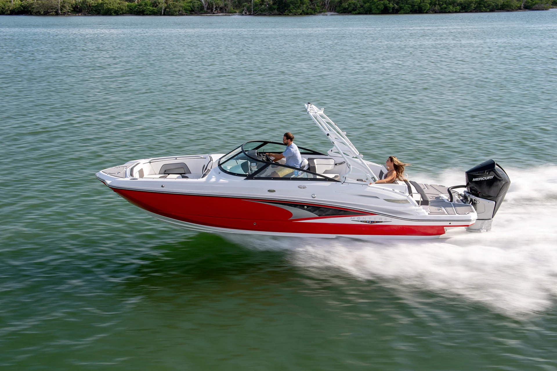 Side profile of a red Monterey M-65 speeding across open water with Mercury outboard power